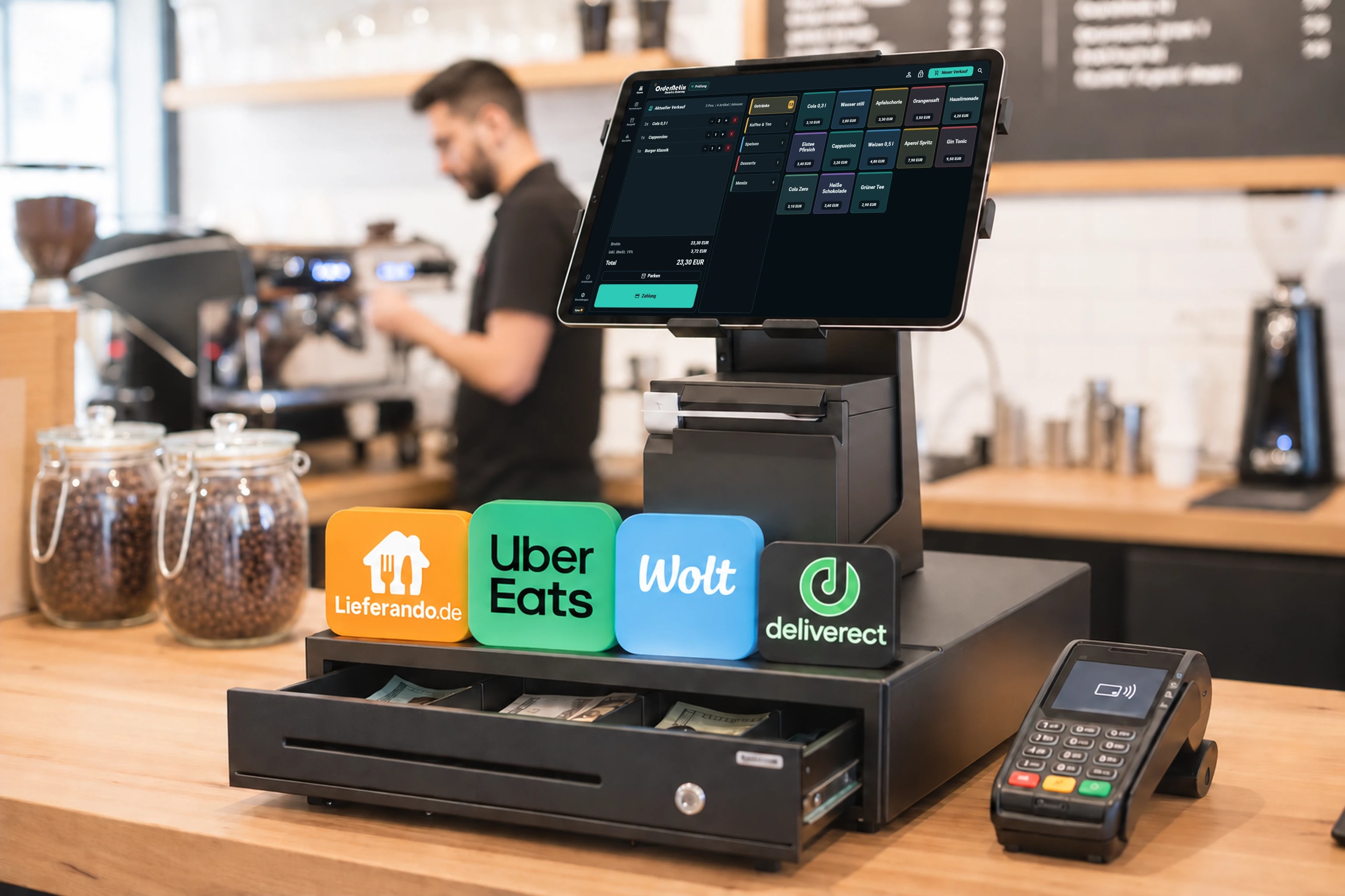 OrderNetix-Kassenoberfläche auf einem Tablet im Café mit Zahlungsterminal und dargestellten Lieferdienst-Logos